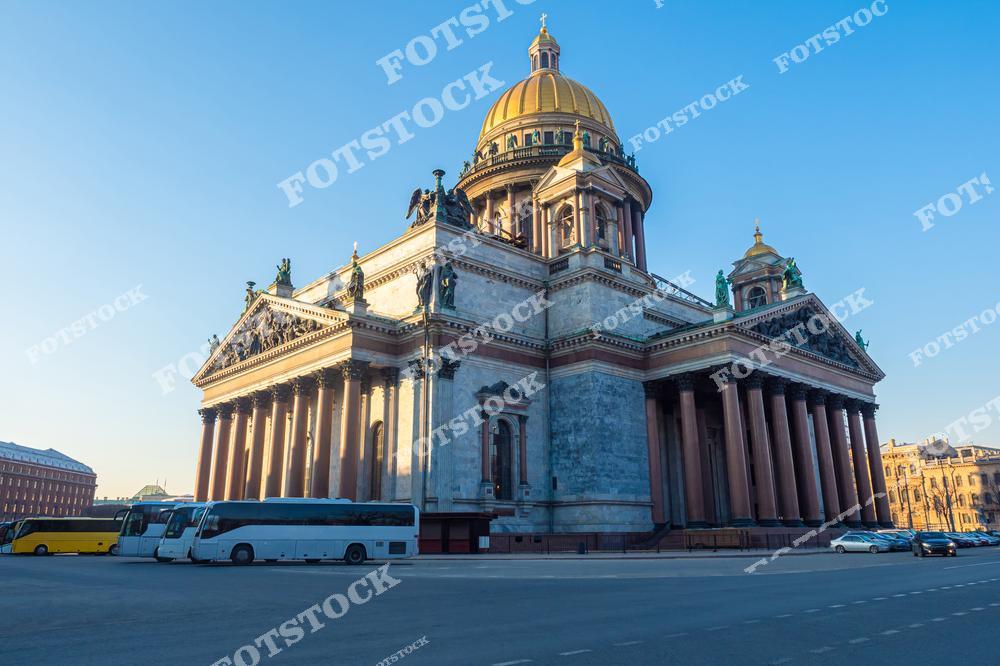 Фотография с видом на Исаакиевский собор в Санкт-Петербурге, Россия, выполненная в летний солнечный день. На изображении запечатлены экскурсионные автобусы на фоне одного из самых известных архитектурных символов Санкт-Петербурга. Фото отлично подходит для туристических сайтов, рекламы автобусных туров, путеводителей, статей о путешествиях по России и Европе, а также для коммерческого использования в сфере туризма. Исаакиевский собор является популярной достопримечательностью Санкт-Петербурга и привлекает туристов со всего мира своей величественной архитектурой и исторической ценностью. Атмосфера летнего города, экскурсионный транспорт и исторический центр делают изображение востребованным для покупки и использования в туристических и информационных проектах.